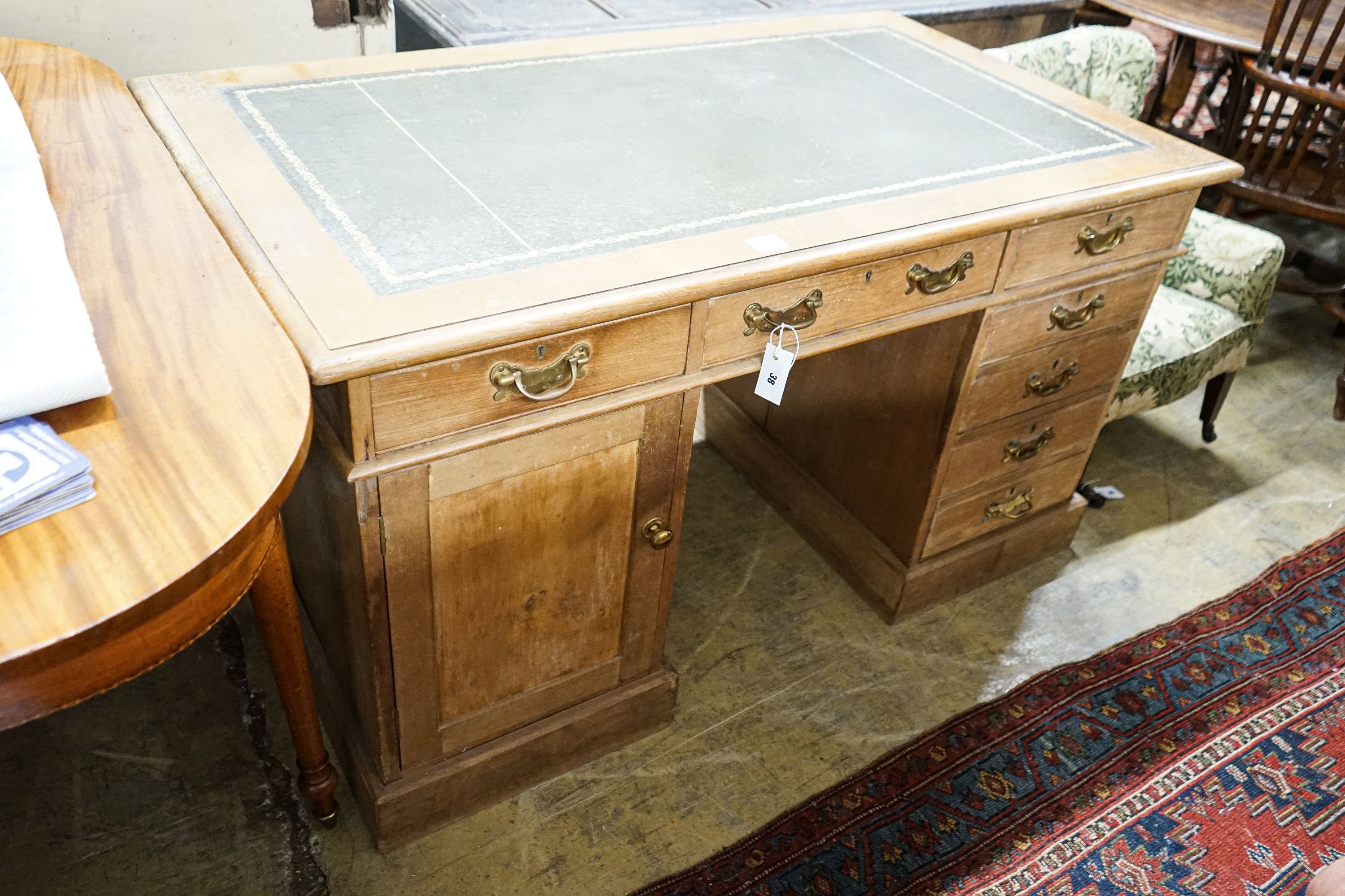 An Edwardian stripped beech pedestal desk, fitted eleven drawers, width 138cm, depth 80cm, height 76cm